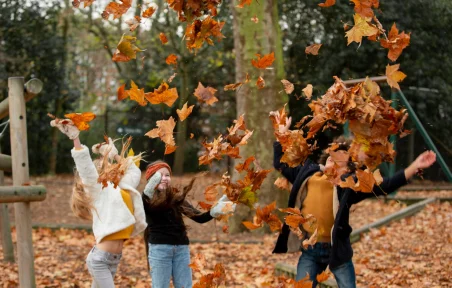 Children playing in autumn leaves