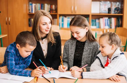 Teacher helping students at a desk